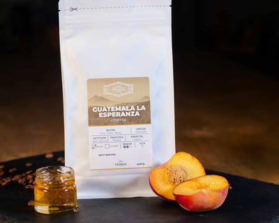 White Coffee Bag with peach and honey next to it to show the tasting notes.