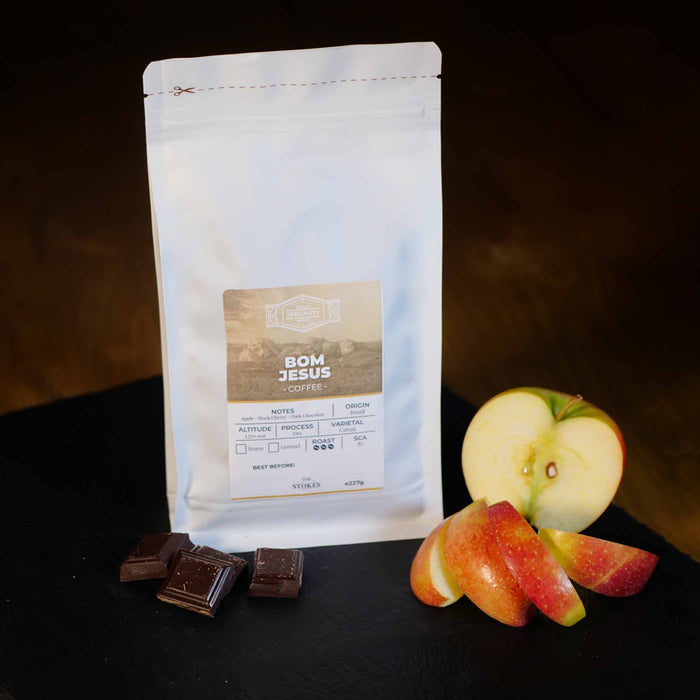 White Coffee Bag with apple and chocolate next to it to show the tasting notes.