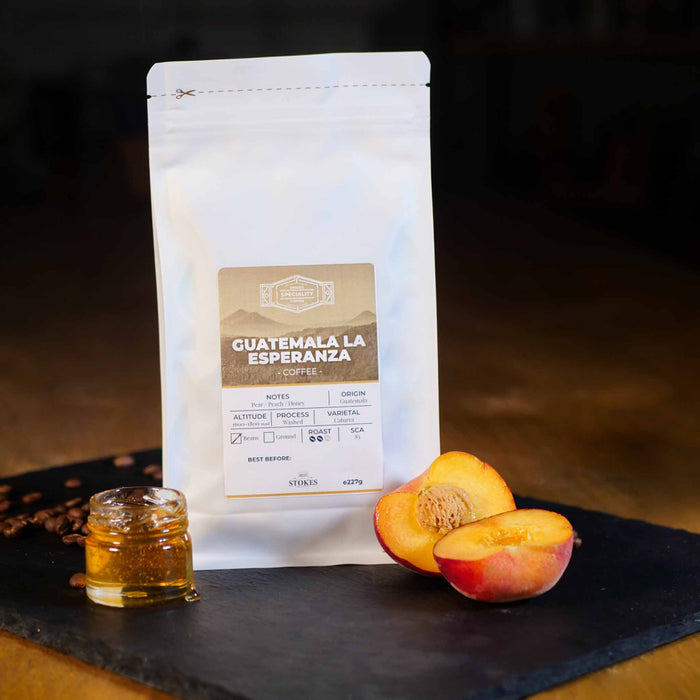 White Coffee Bag with peach and honey next to it to show the tasting notes.
