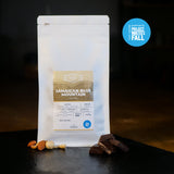 White Coffee Bag with Label. Chocolate and nuts next to the bag to show the tasting notes. Project Waterfall logo in the top right