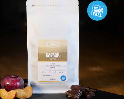 Kenyan Burundi Coffee with plum and chocolate next to it. Project waterfall badge in the top right